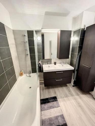 une salle de bain avec une baignoire et un lavabo et une baignoire dans l'établissement Le Panoramique - Sublime vue sur la Cité, à Carcassonne