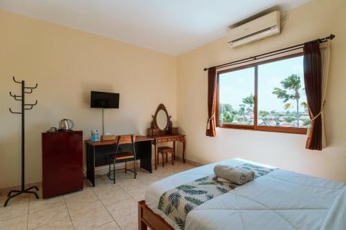 a bedroom with a bed and a desk and a window at Umah Kita in Seminyak