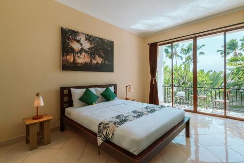 a bedroom with a bed and a large window at Umah Kita in Seminyak
