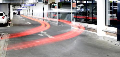 a street with cars driving past a building at Yours Truly in Munich