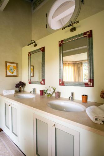 a bathroom with two sinks and a mirror at Au petit jardin in Ravenna