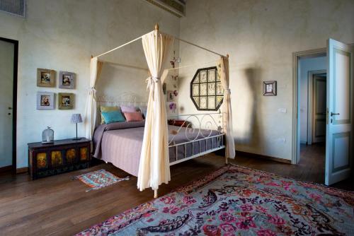una camera con letto a baldacchino e tappeto di Au petit jardin a Ravenna