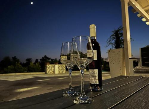 Dois copos de vinho e uma garrafa de vinho numa mesa em Villa in campagna vicina al mare ( nuova anno 2022) em Uggiano la Chiesa