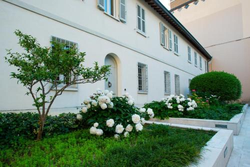 un edificio con fiori bianchi di fronte di Au petit jardin a Ravenna