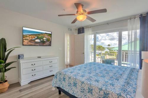 a bedroom with a bed and a ceiling fan at New Luxury Condo w/ Heated Pool 1 Block From Gulf in St Pete Beach