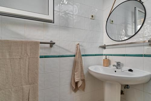 Un baño blanco con lavabo y espejo. en Nerja Atico, en Nerja