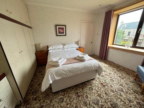 a bedroom with a large bed and a window at Taigh Na Casag in Lionel