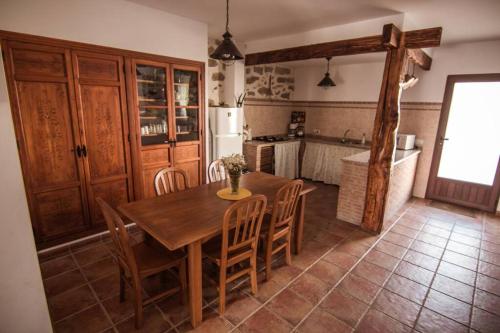 a kitchen with a wooden table and some chairs at Piedras Vivas in Anora