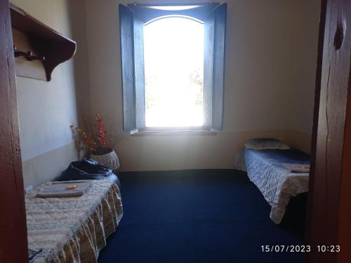 a room with two beds and a window at Bonserá do Madeira in Lavras