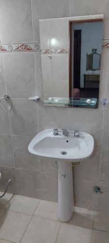 bagno con lavandino bianco e specchio di LS Alojamientos Posadas Misiones a Posadas