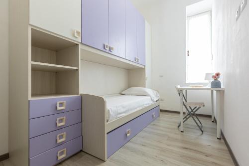 a small bedroom with a bed and a desk at Espinasse Apartment in Milan
