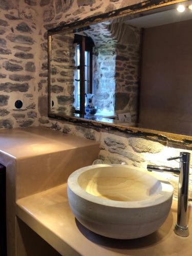 a stone bathroom with a toilet and a mirror at Dreamy Cottage in Ayiá