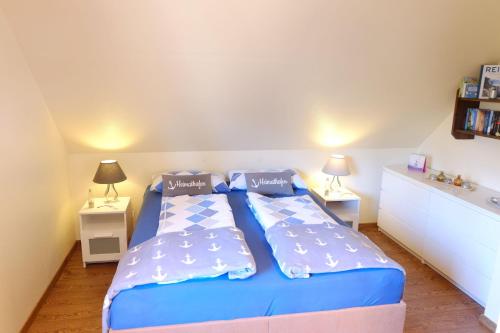 グリュックスブルクにあるFerienwohnung Violaのベッドルーム1室(青いベッド1台、ランプ2つ付)
