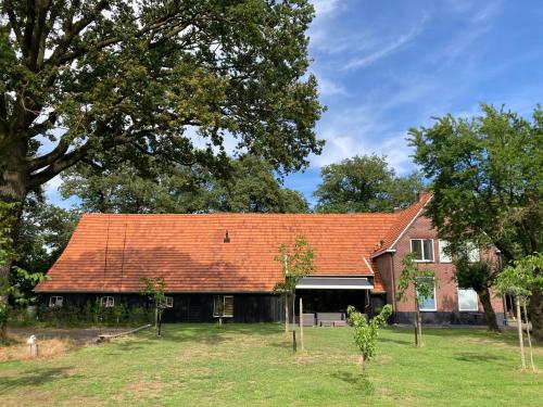 an old house with a red roof at Hoeve de Snippert in Groenlo