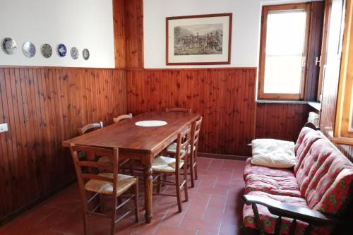 Appartamento Villa Marta في سبوليتو: غرفة طعام مع طاولة خشبية وأريكة