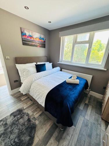 a bedroom with a large bed and two windows at Burmese - 5 Bedroom House in Earley