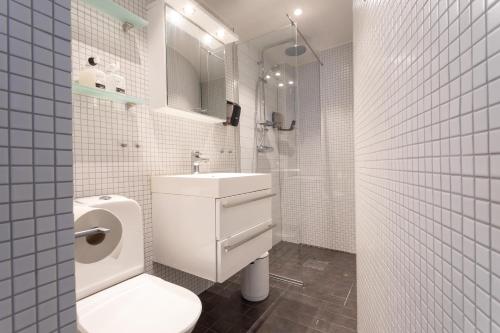 a white bathroom with a toilet and a sink at ApartDirect Gamla Stan III in Stockholm