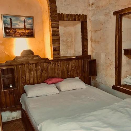 una camera con letto e testata in legno di Alkan konuk evi a Şanlıurfa