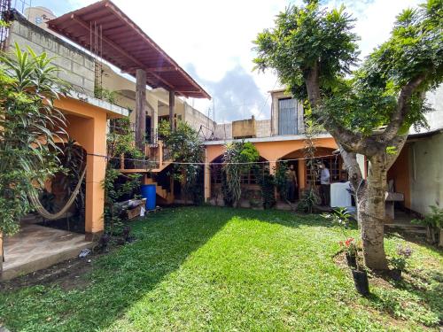 un patio frente a una casa con un árbol en The guesthouse en Panajachel