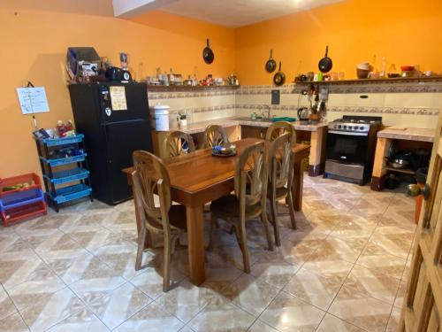 uma cozinha com uma mesa de madeira e cadeiras em The guesthouse em Panajachel