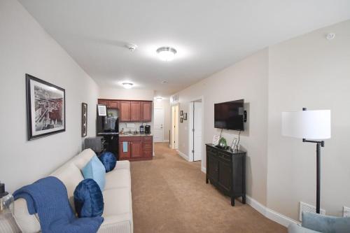 a living room with a white couch and a television at Stay at the Historic Inman in Champaign