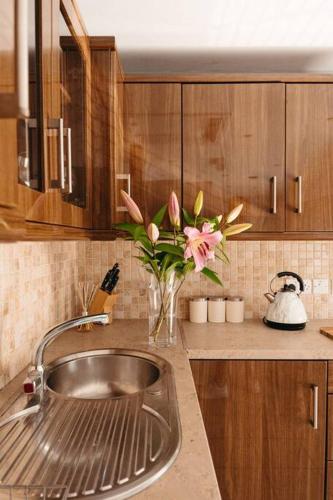 a kitchen with a sink and a vase of flowers at Cuilcagh View Apartment Belcoo in Enniskillen