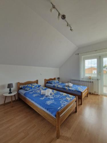 1 dormitorio con 2 camas, mesa y ventana en Green House Apartment, en Pivka