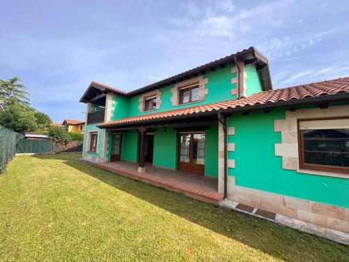 une maison verte avec une cour dans l'établissement Espectacular Casona Montañesa, à Ibio