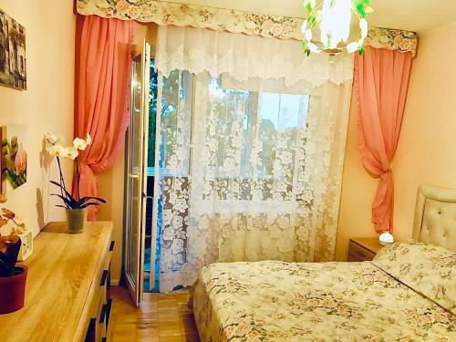 a bedroom with a bed and a window at Комната с лоджией у Татьяны in Jūrmala