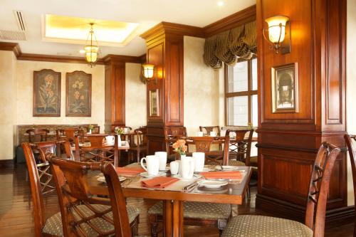uma sala de jantar com uma mesa de madeira e cadeiras em Plaza Grande Hotel em Quito