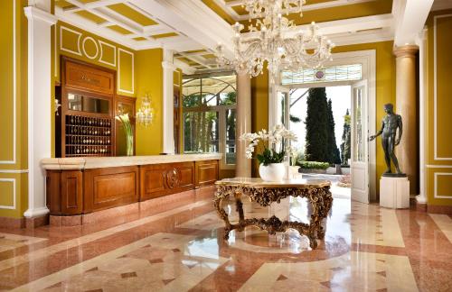 a lobby with a statue and a table in it at Villa Cortine Palace Hotel in Sirmione