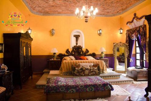 a bedroom with a bed and a chandelier at Hacienda La Gioconda in Nopala