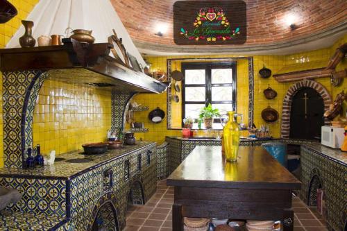 una cocina con paredes de baldosas amarillas y una mesa. en Hacienda La Gioconda, en Nopala