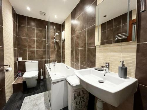 een badkamer met een wastafel, een toilet en een wastafel bij High Gables Apartment 2 in Paignton