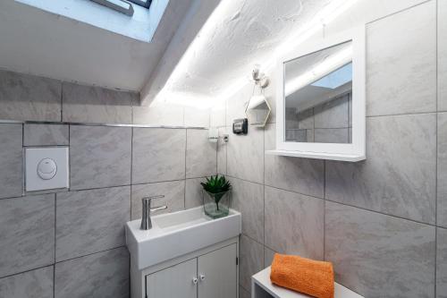 a bathroom with a sink and a mirror at JOIVY Al Duomo guest house in Como