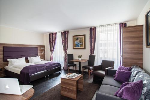 a hotel room with a bed and a couch at BATU Apart Hotel in Munich