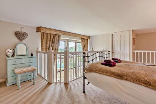 a bedroom with a bed and a balcony at The Old School House in Stow on the Wold