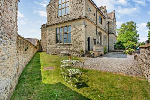 a table and chairs in the yard of a building at The Old School House in Stow on the Wold