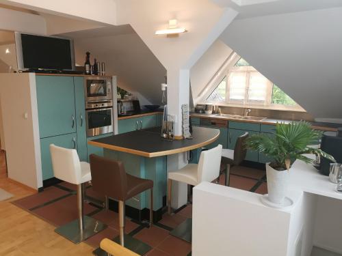 une cuisine avec des armoires bleues, une table et des chaises dans l'établissement Ferienwohnung DG, à Altenkunstadt