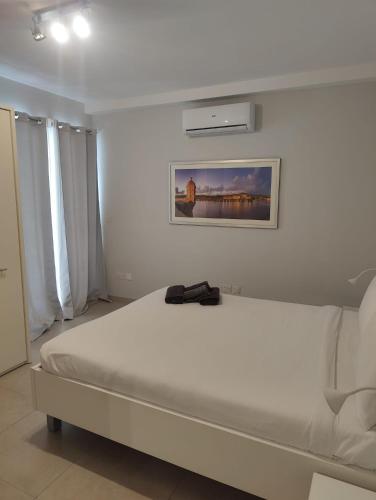 a bedroom with a white bed with a bag on it at Gżira, 2 bedroom apartment in Il-Gżira