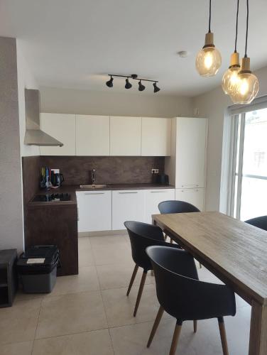 a kitchen with a wooden table and black chairs at Gżira, 2 bedroom apartment in Il-Gżira