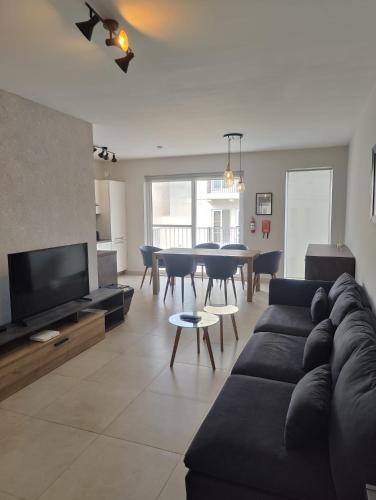 a living room with a couch and a dining room at Gżira, 2 bedroom apartment in Il-Gżira