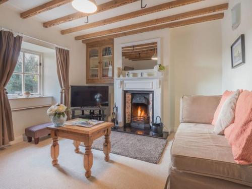 a living room with a couch and a fireplace at Roses Cottage - near Scafell Comfy Modern Idyllic in Santon Bridge