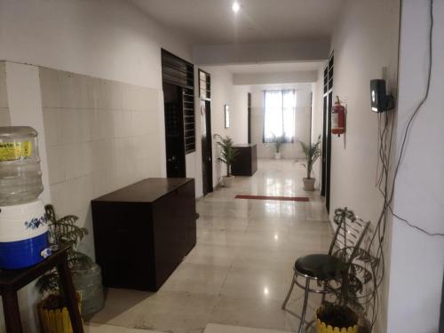 a room with a hallway with a room with a table and chairs at Apna Guest House Dehradun in Dehradun