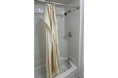 a bathroom with a shower curtain next to a bath tub at Love Hotels Badlands National Park at Kadoka SD in Kadoka