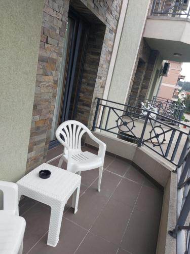 Vrnjačka Banja的住宿－Apartmani Lenka，阳台配有两把椅子、一张桌子和一辆自行车