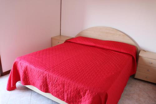 Appartamento Giove في بيبيوني: غرفة نوم بسرير وبطانية حمراء