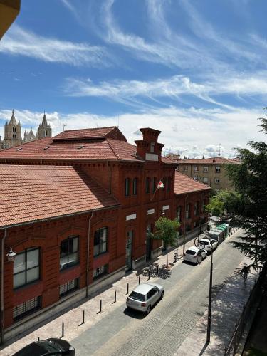 a street with cars parked in front of buildings at Hostal Restaurante Boccalino in León