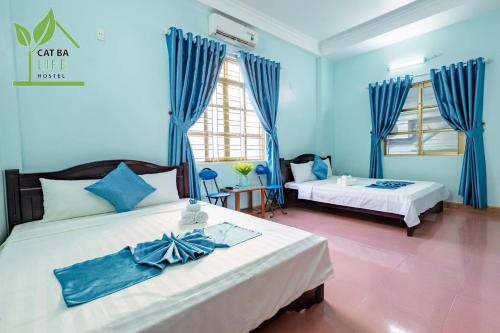 1 dormitorio con 2 camas y paredes azules en Cat Ba Life Hostel en Hai Phong
