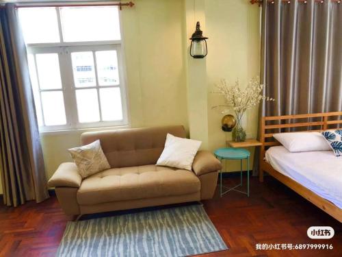 - un salon avec un canapé et un lit dans l'établissement 曼谷自由之家, à Klong Toi